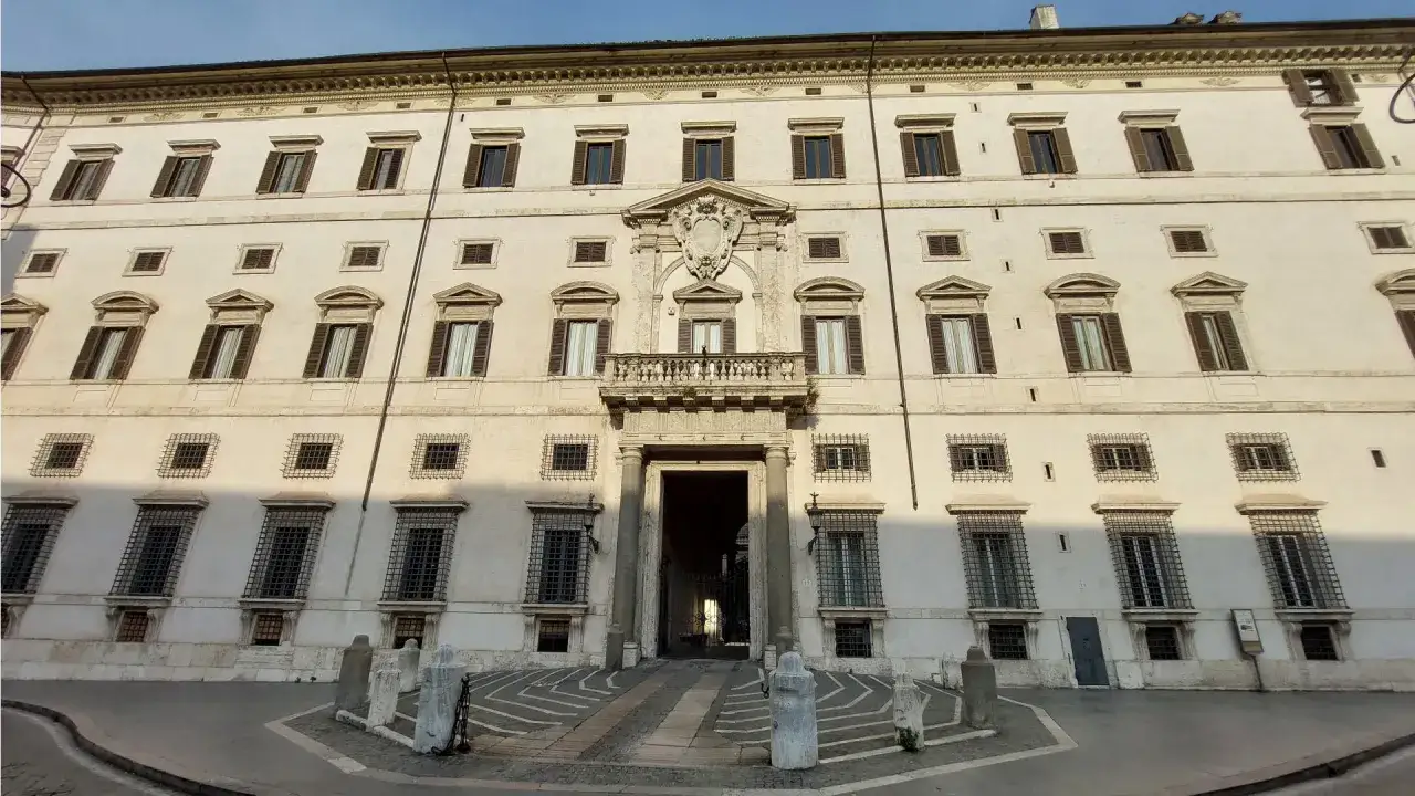 Façade imposante du **Palais Borghese** à Rome, avec ses fenêtres symétriques, son balcon orné et son entrée voûtée.