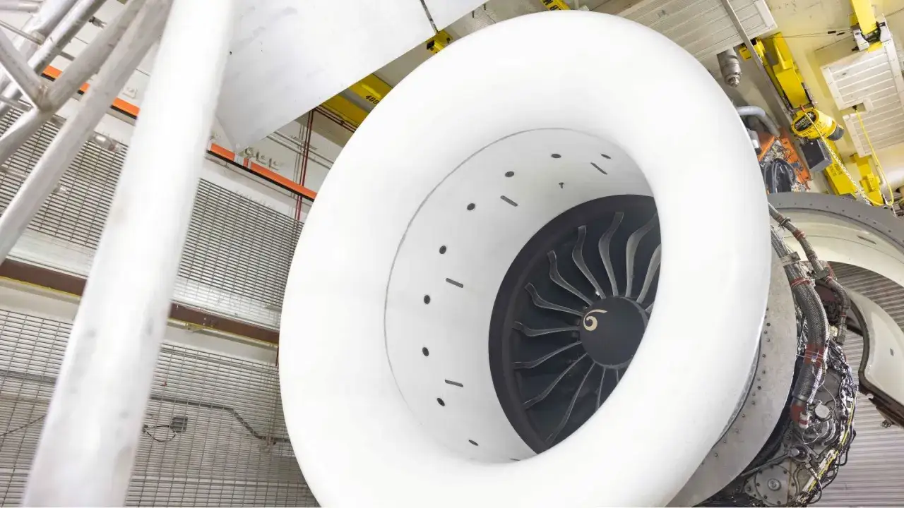 Silnik turbowentylatorowy samolotu Airbus A321 271NX w warsztacie. Widok na wirnik i białą obudowę.