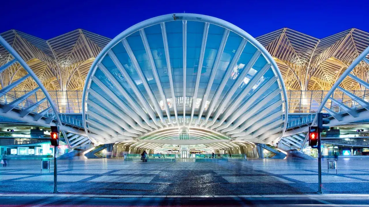 Moderne Architektur am **Lisbon main train station** mit einem geschwungenen Glasdach und einem filigranen Holzfachwerk im Hintergrund.