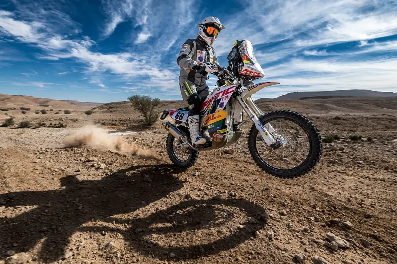Franco Picco in azione nel deserto, solleva polvere con la sua moto da rally.