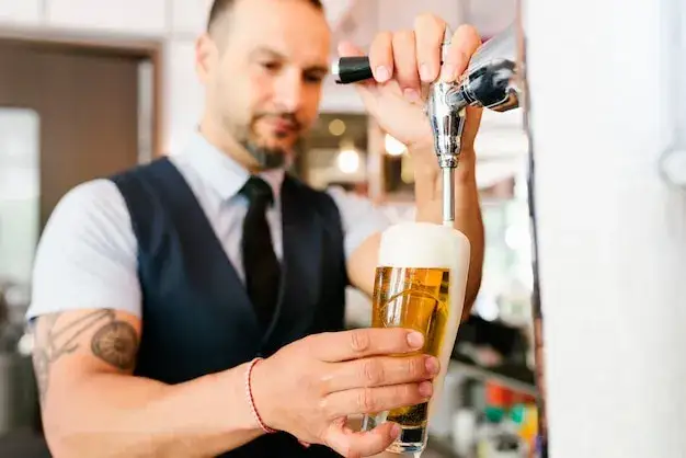 barman w angielskim pubie nalewający piwo