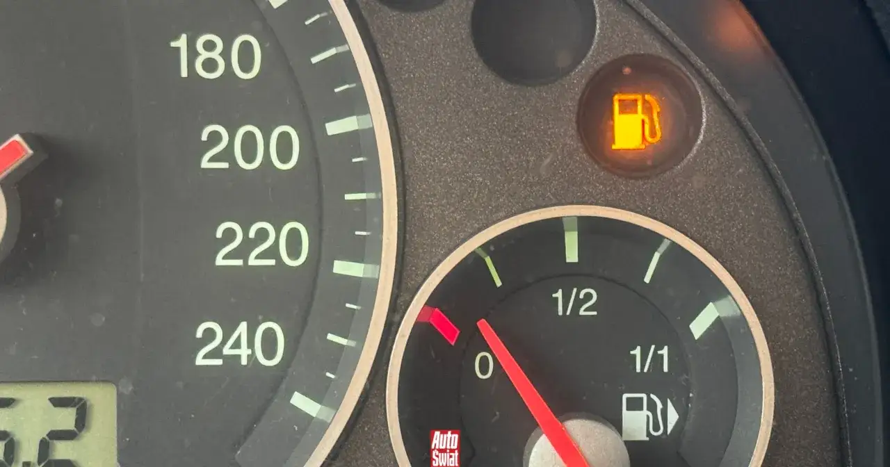 Wskaźnik paliwa na desce rozdzielczej pokazuje niski poziom. Lampka rezerwy świeci się, sugerując, że pozostało niewiele paliwa. Ile km na rezerwie diesel? Trudno powiedzieć, ale lepiej szybko tankować!
