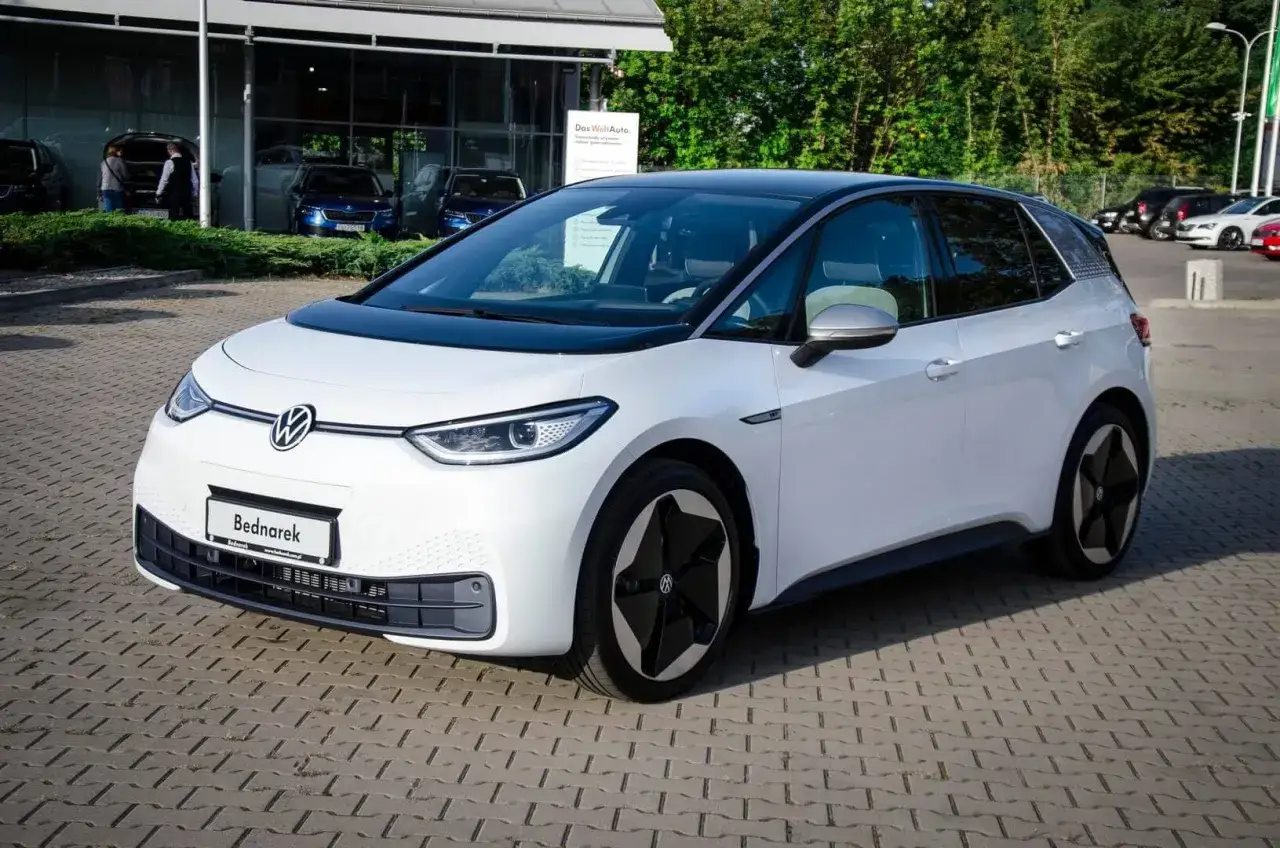 Biały Volkswagen ID.3 na placu dealerskim. Sprawdź aktualne ceny aut elektrycznych i wybierz swój wymarzony model.