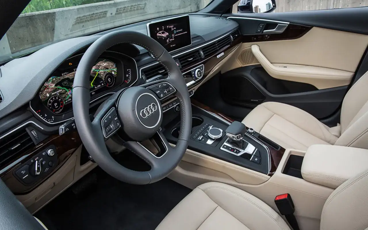 Wnętrze Audi A5 2018 z jasną tapicerką, cyfrowym kokpitem i nawigacją.