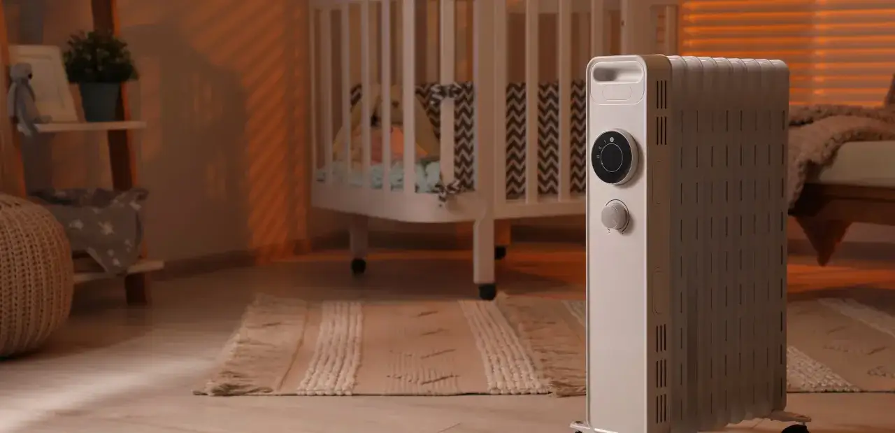 Calentador el&eacute;ctrico en una habitaci&oacute;n infantil, con una cuna y una alfombra. La luz anaranjada crea un ambiente acogedor, como un calor azul.