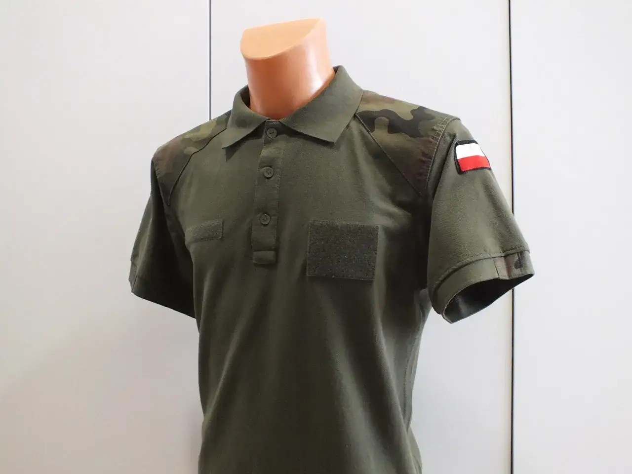 Zielona koszulka polo wojskowa MON z naszywkami moro na ramionach i polską flagą.