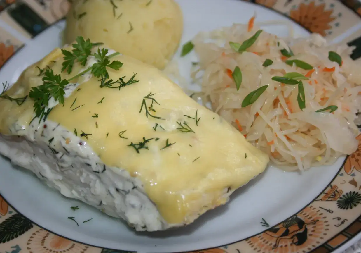 Dorsz czarny zapieczony pod serem, podany z puree ziemniaczanym i surówką z kiszonej kapusty.