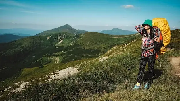 Turysta idący zielonym szlakiem w górach, zróżnicowany teren
