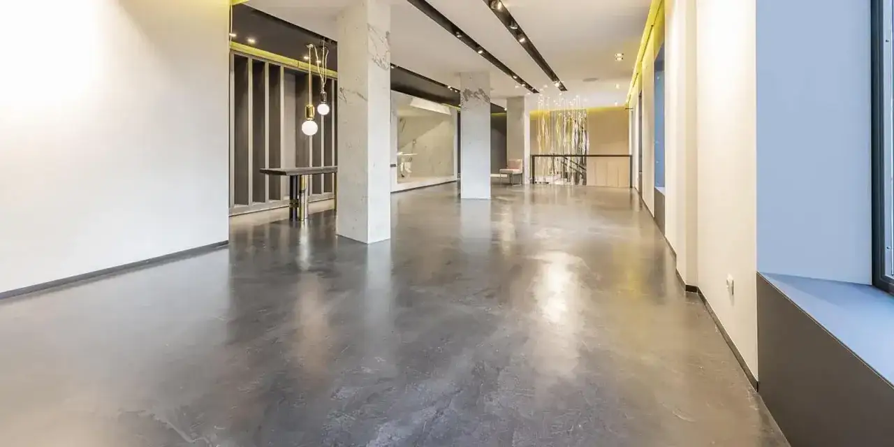 Modernt, ljust utrymme med en blank betonggolv som ger en sofistikerad känsla. Denna behandling av betonggolv skapar en elegant och hållbar yta.