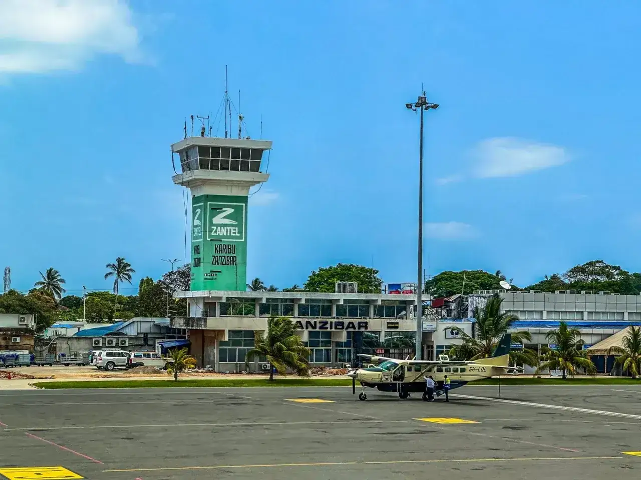 Lotnisko na Zanzibarze. Wieża kontroli lotów Zantel i mały samolot na płycie lotniska. Czas zacząć planować, ile się leci na Zanzibar!