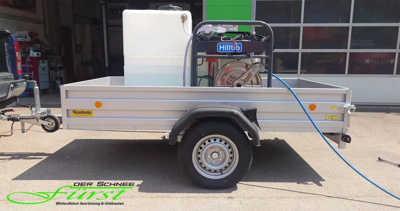 Ein **Hochdruckreiniger-Anhänger** mit großem Wassertank und Hilti-Gerät, bereit für den Einsatz.