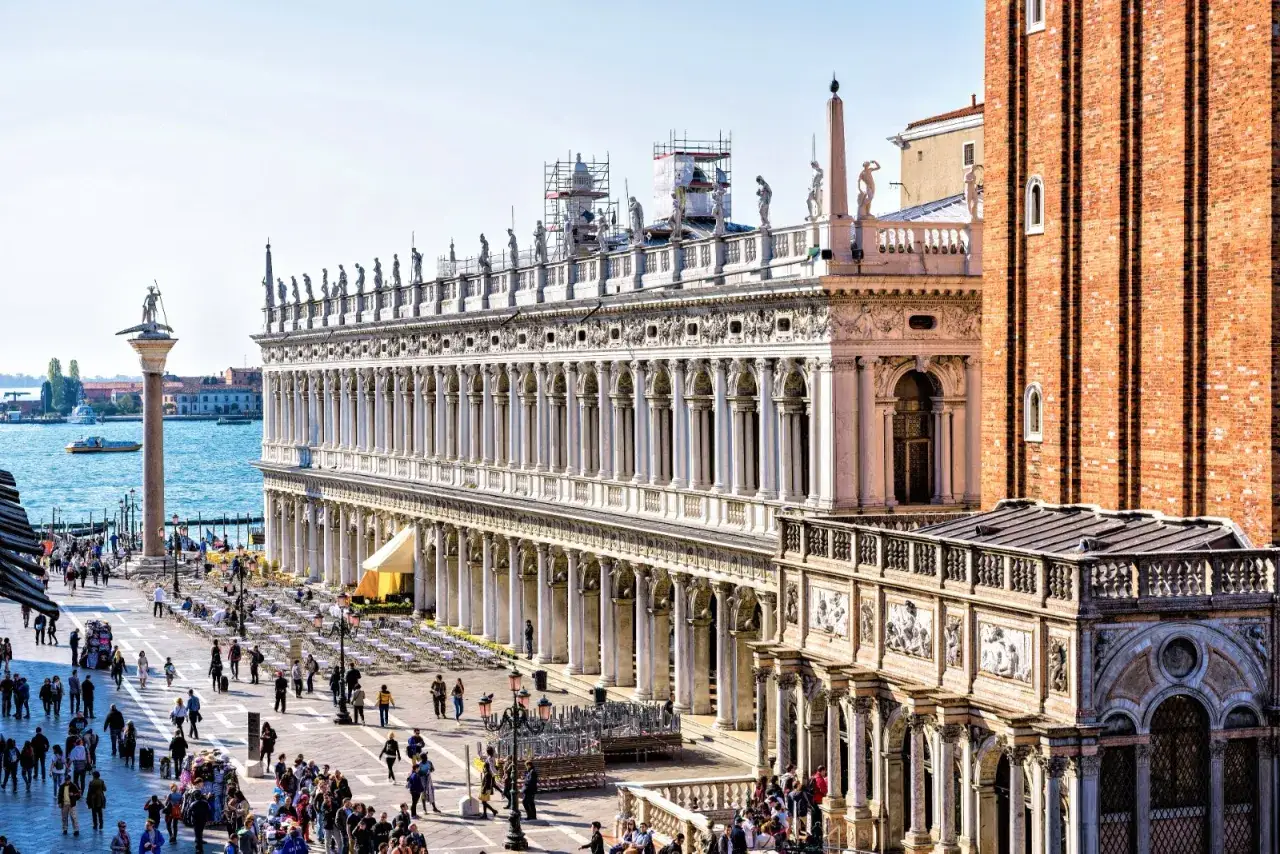 La **bibliothèque Marciana** de Venise, avec sa façade ornée, borde une place animée.