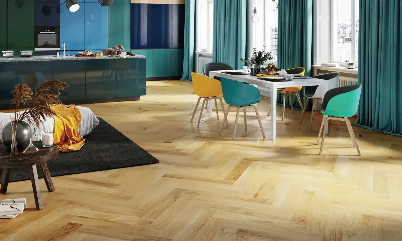 Vacker fiskbensparkett i ljust trä ger en varm känsla. Tänk på kostnad fiskbensparkett vid renovering. Modernt kök och matplats med färgglada stolar.