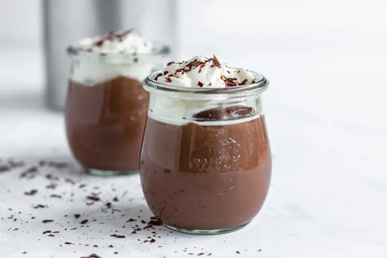 Zwei Gl&auml;ser mit Omas Schokoladenpudding mit Sahne und Schokostreuseln. Ein Genuss wie fr&uuml;her!