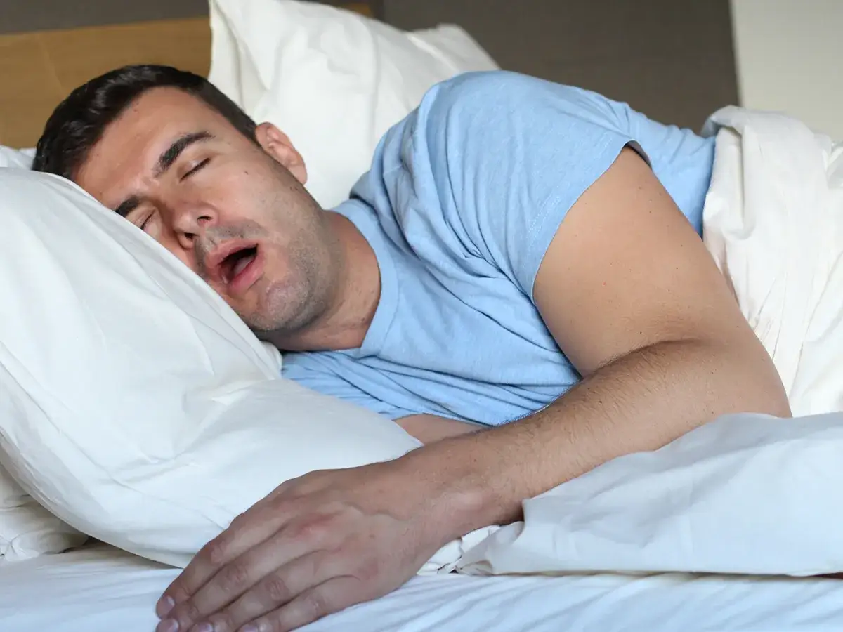 Uomo dorme a bocca aperta, con un braccio sul cuscino. Chiss&agrave; perch&egrave; si sbava quando si dorme, ma lui sembra rilassato.