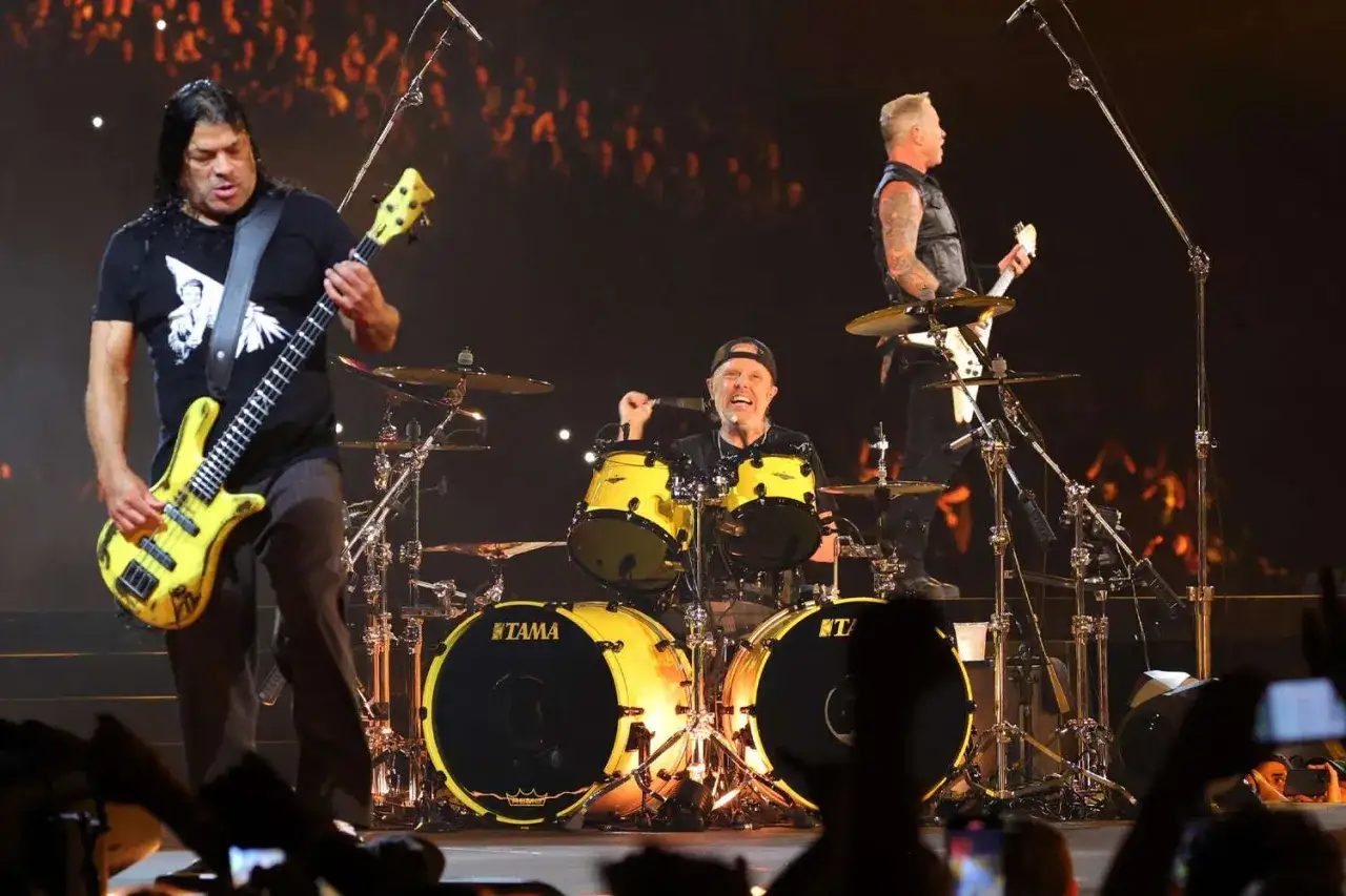 Metallica członkowie: Robert Trujillo gra na basie, Lars Ulrich za perkusją, James Hetfield na gitarze.
