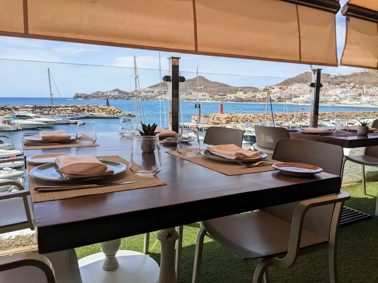 Mesa puesta en la terraza de Casa Sebastián San José, con vistas al puerto y al mar.