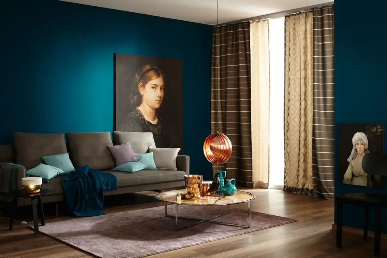 Ein Wohnzimmer mit petrolfarbenen W&auml;nden. Welche Farbe passt zu petrol? Hier Braun und Beige als Akzente.