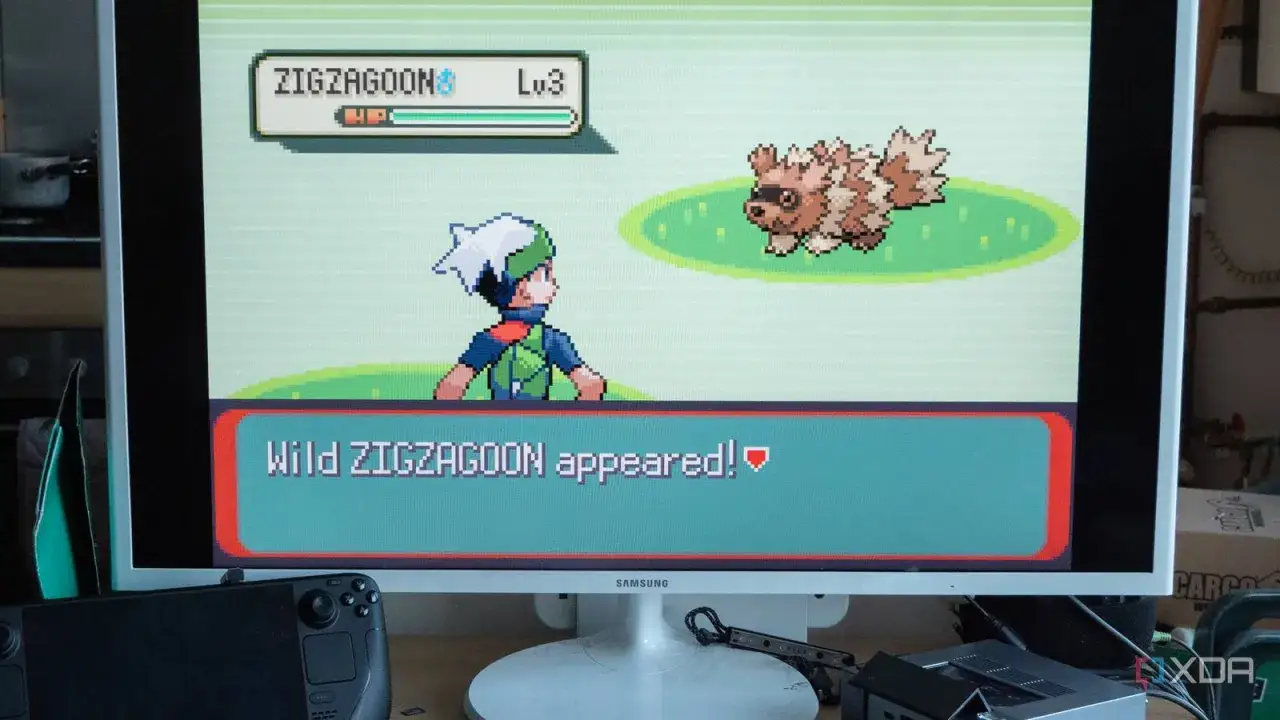 Gracz walczy z dzikim Zigzagoonem na ekranie monitora, grając w gry Pokemon na PC.