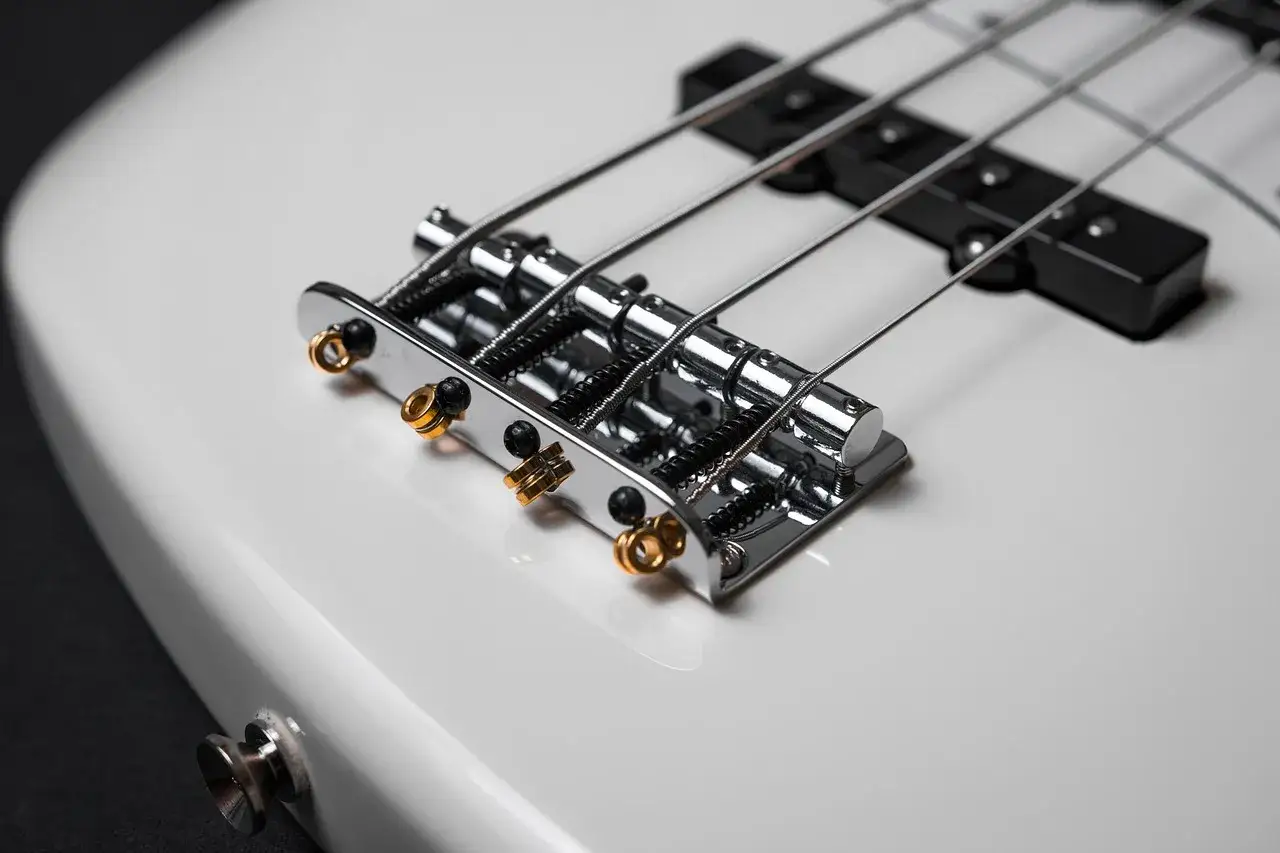 Biała gitara basowa z czterema strunami.