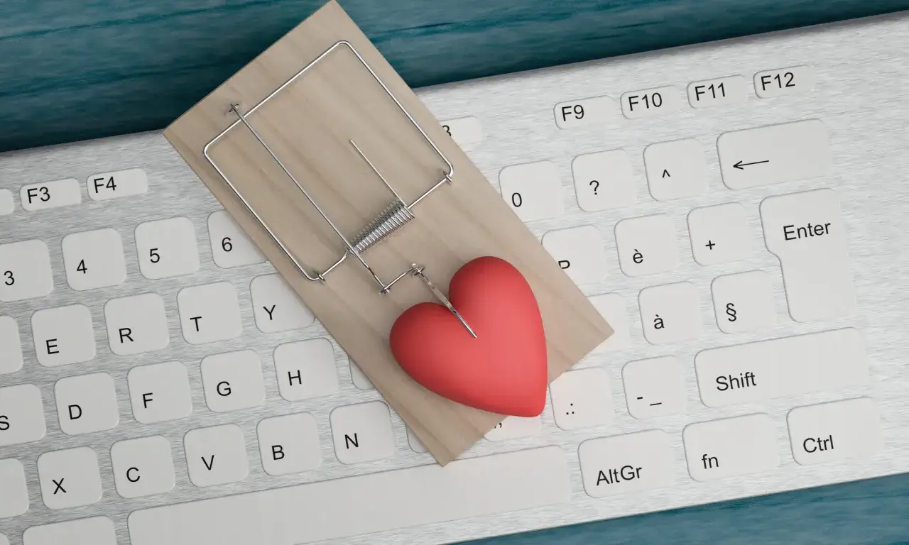 Mausefalle mit Herz auf Tastatur. Vorsicht vor Online-Fallen beim Catfishing.