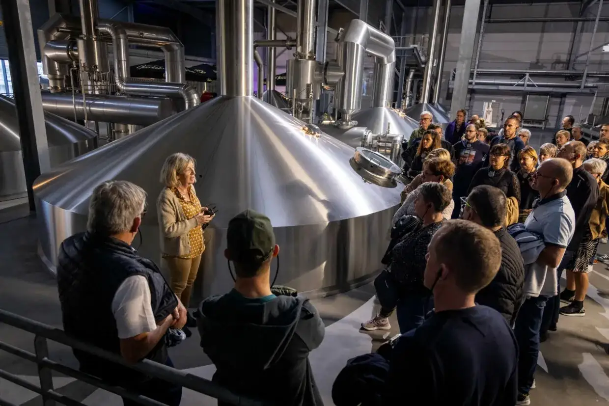 Visite Goudale : un groupe découvre les cuves de brassage. Une guide explique le processus de fabrication de la bière.