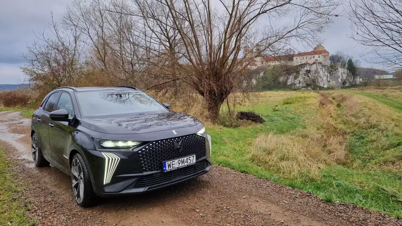 Czarny DS7 Crossback na drodze gruntowej, w tle zamek na skale i jesienna przyroda.