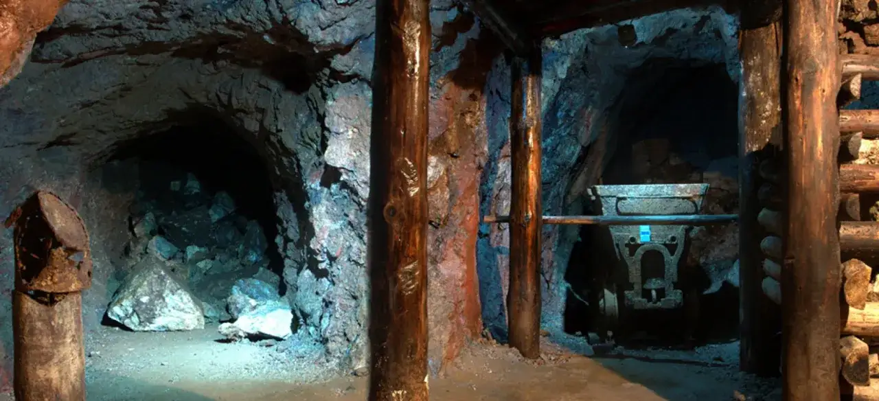Wnętrze kopalni z drewnianymi podporami i wózkiem górniczym. Odkryj śląskie atrakcje i poczuj klimat podziemi.