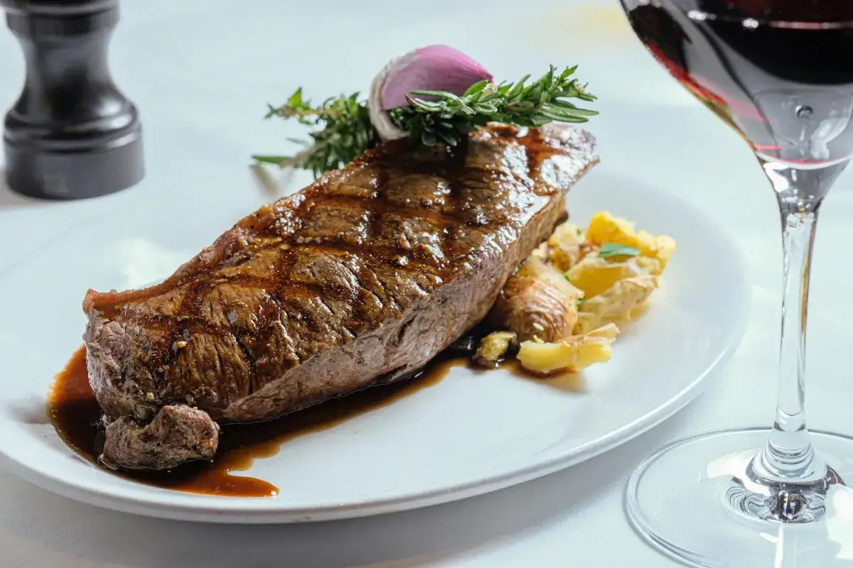 En saftig entrecote med rostade potatisar, garnerad med rosmarin och vitlök. Perfekt vin till entrecote.