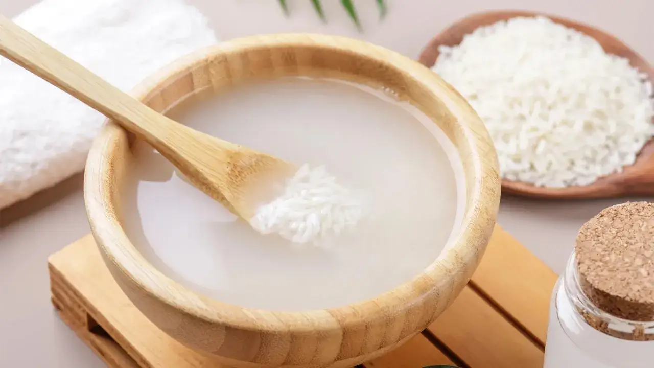 Un taz&oacute;n de madera con agua de arroz para el pelo, una cuchara de bamb&uacute; y un cuenco con arroz crudo.