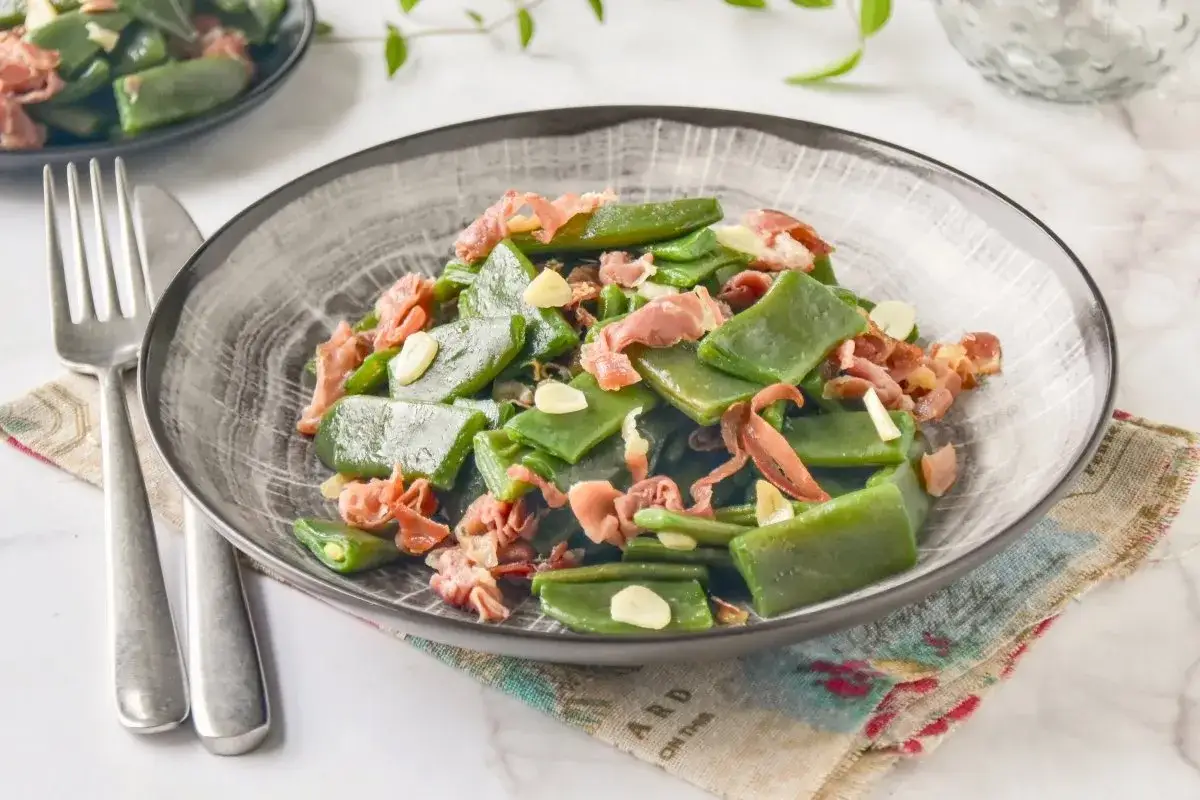 Judías verdes salteadas con trocitos de jamón serrano y láminas de ajo, un plato sencillo y delicioso.