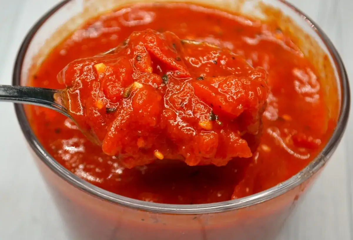 Ein Löffel voller leuchtend roter San Marzano Tomaten, bereit für eine köstliche Pasta.
