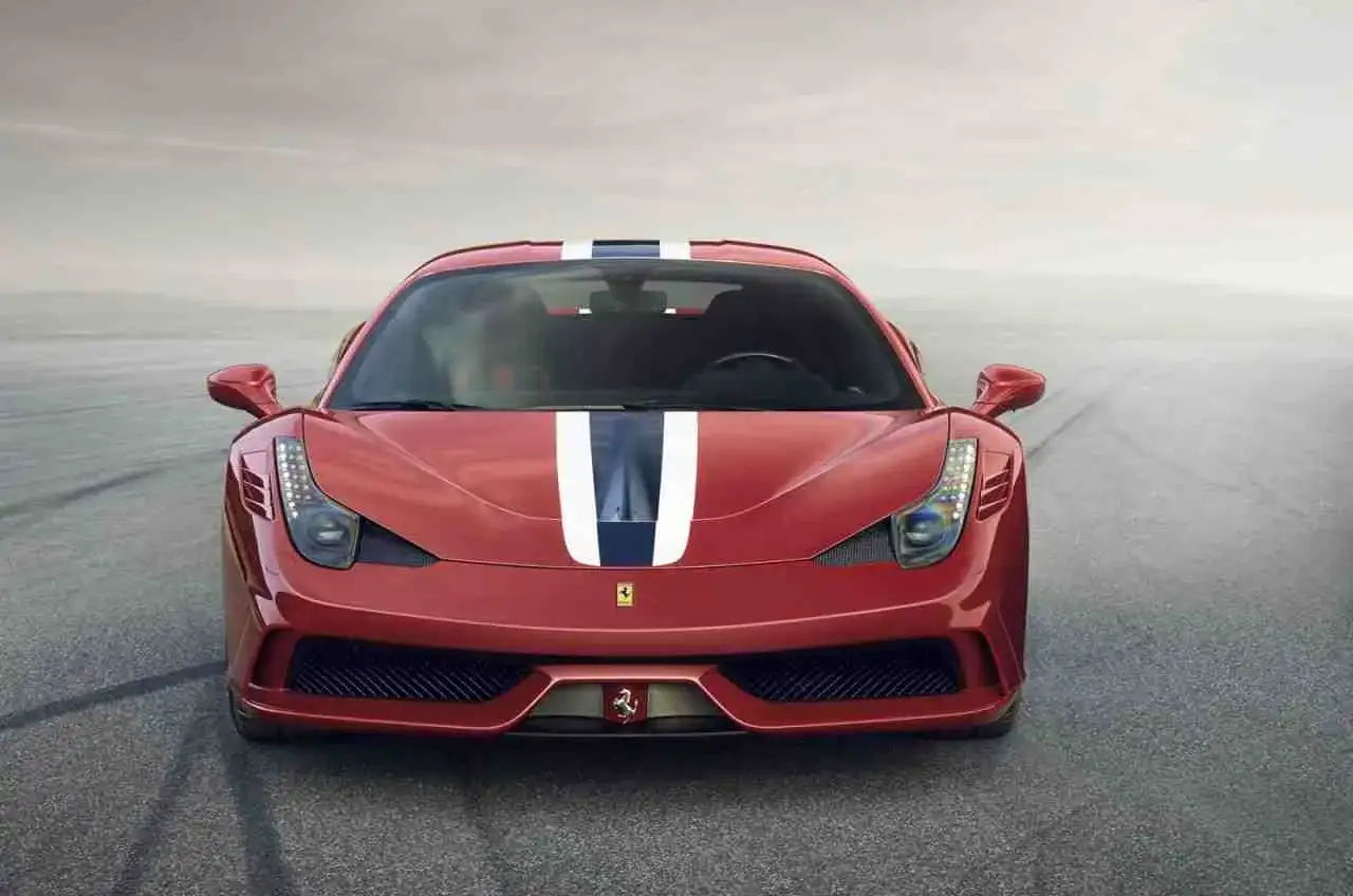 Czerwone Ferrari 458 z białymi i granatowymi pasami na masce, gotowe do jazdy po torze.