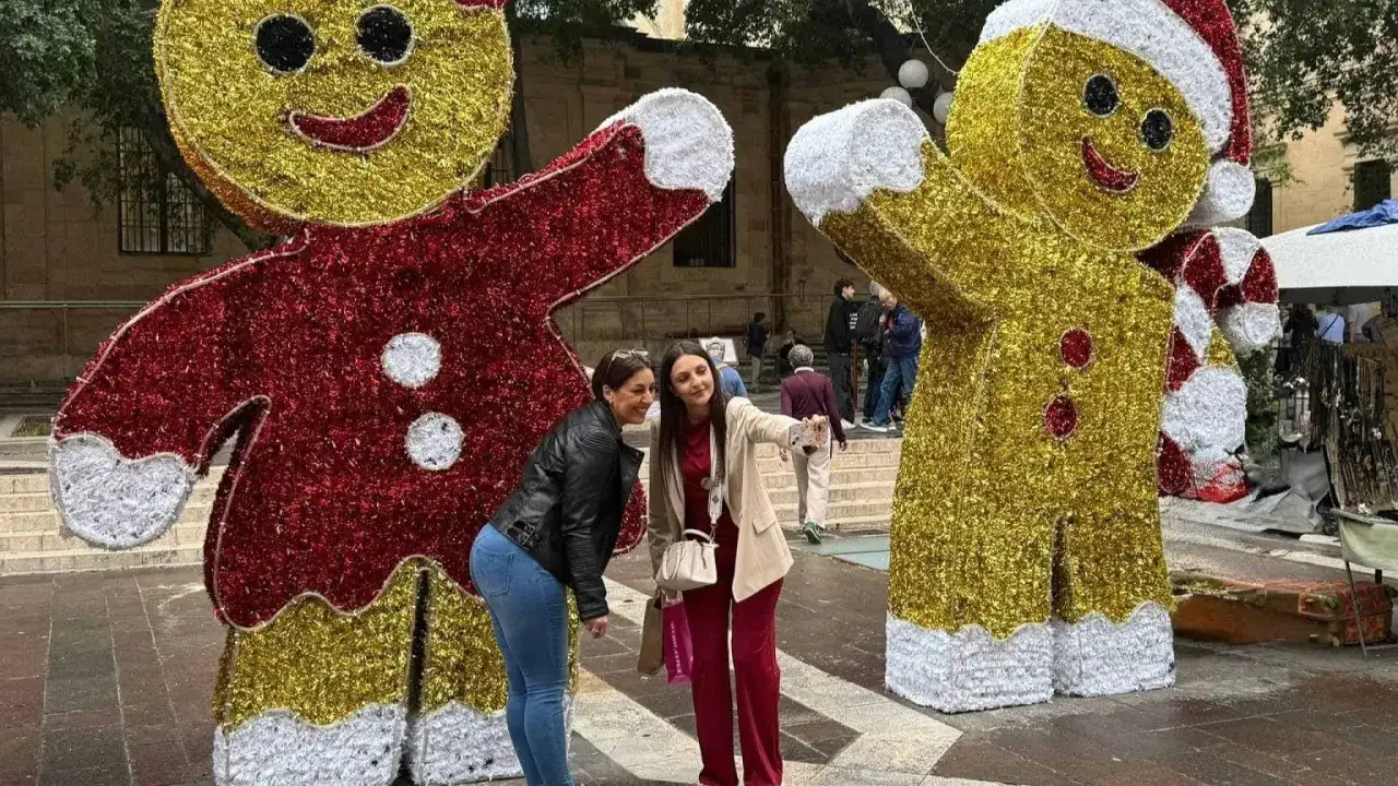Malta w grudniu: dwie kobiety robią sobie zdjęcie z gigantycznymi piernikowymi ludzikami.