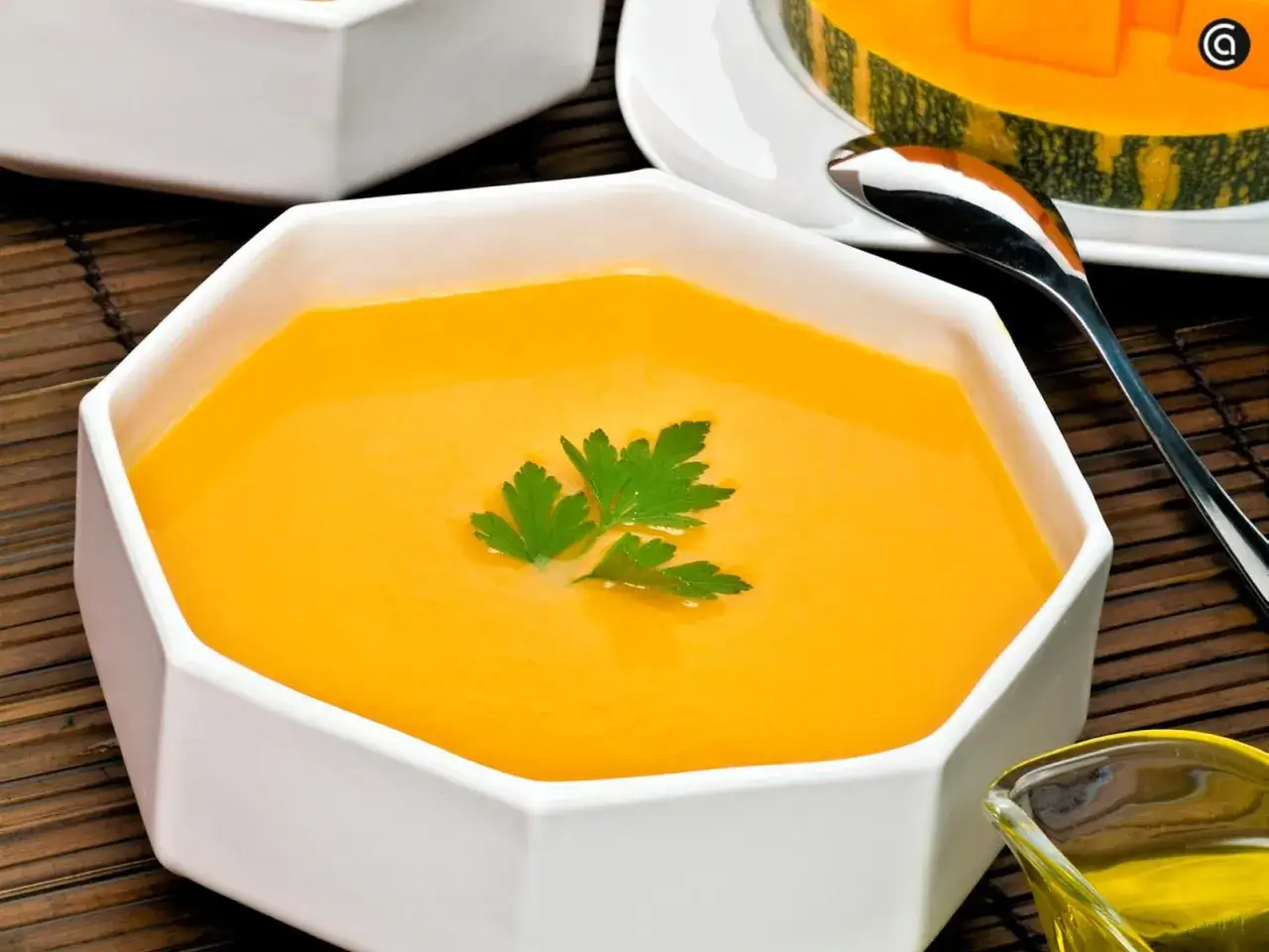 Un cremoso puré de calabaza, decorado con perejil fresco, listo para disfrutar.