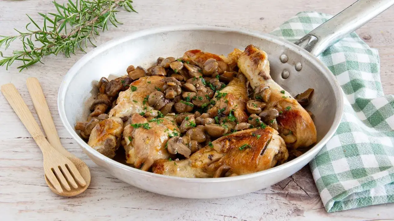 Succulento pollo con funghi trifolati in padella, guarnito con prezzemolo fresco. Un piatto rustico e saporito.