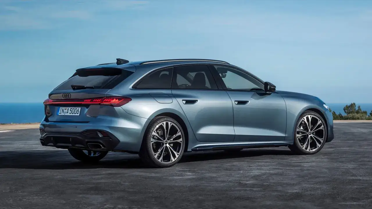 Nowy Audi A5 2025 Avant w kolorze błękitnym, prezentujący dynamiczną sylwetkę na tle błękitnego nieba i morza.