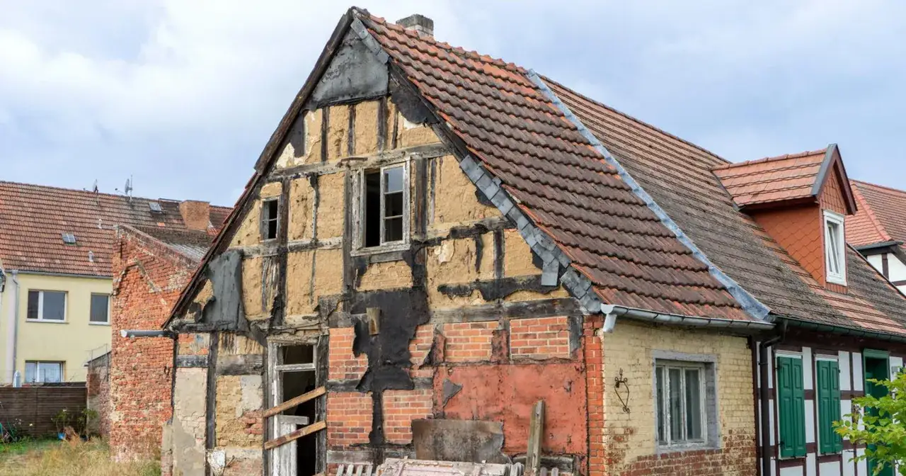 Stary dom z widocznymi belkami konstrukcyjnymi i ceglanymi ścianami, czekający na remont.
