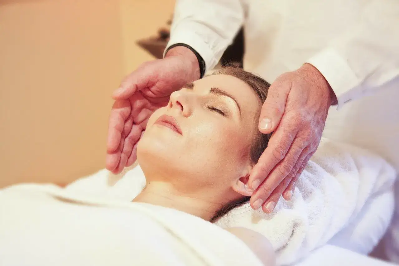 Relaks w La Siesta Medical Spa: dłonie terapeuty delikatnie unoszą głowę kobiety podczas zabiegu.
