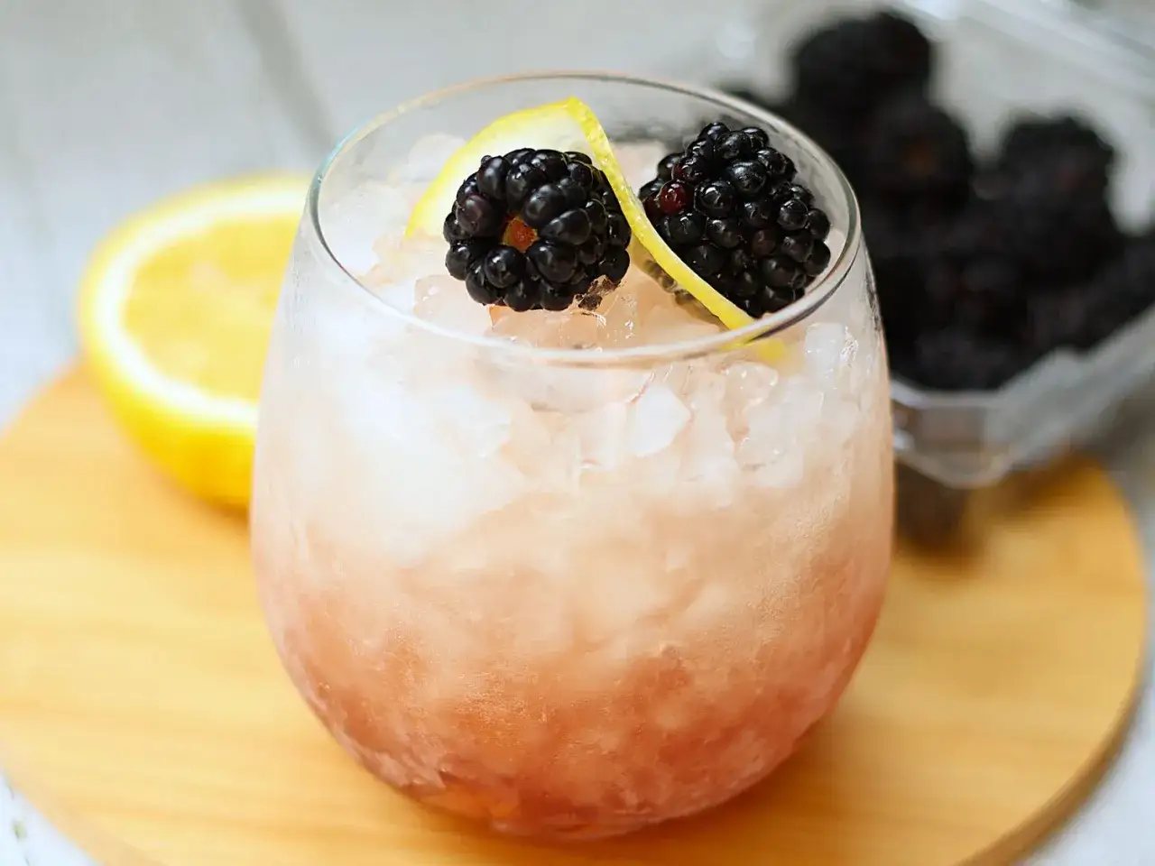 En uppfriskande bramble drink med bj&ouml;rnb&auml;r och citron, serverad med krossad is.
