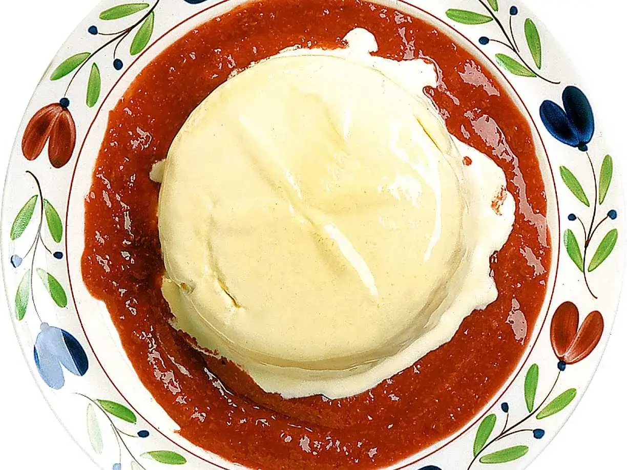 Kr&auml;mig vaniljparfait p&aring; en vackert dekorerad tallrik, omgiven av en r&ouml;d b&auml;rs&aring;s. Ett perfekt recept f&ouml;r en somrig dessert.