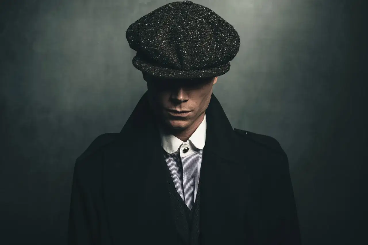 Mężczyzna w kaszkiecie i płaszczu, uosobienie stylu lat 20. moda męska polska.