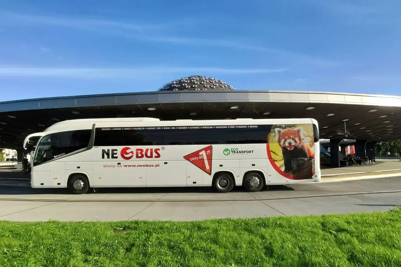 Biały autokar Neobus z pandą małą na boku, gotowy do podróży z Krakowa do Katowice Airport.