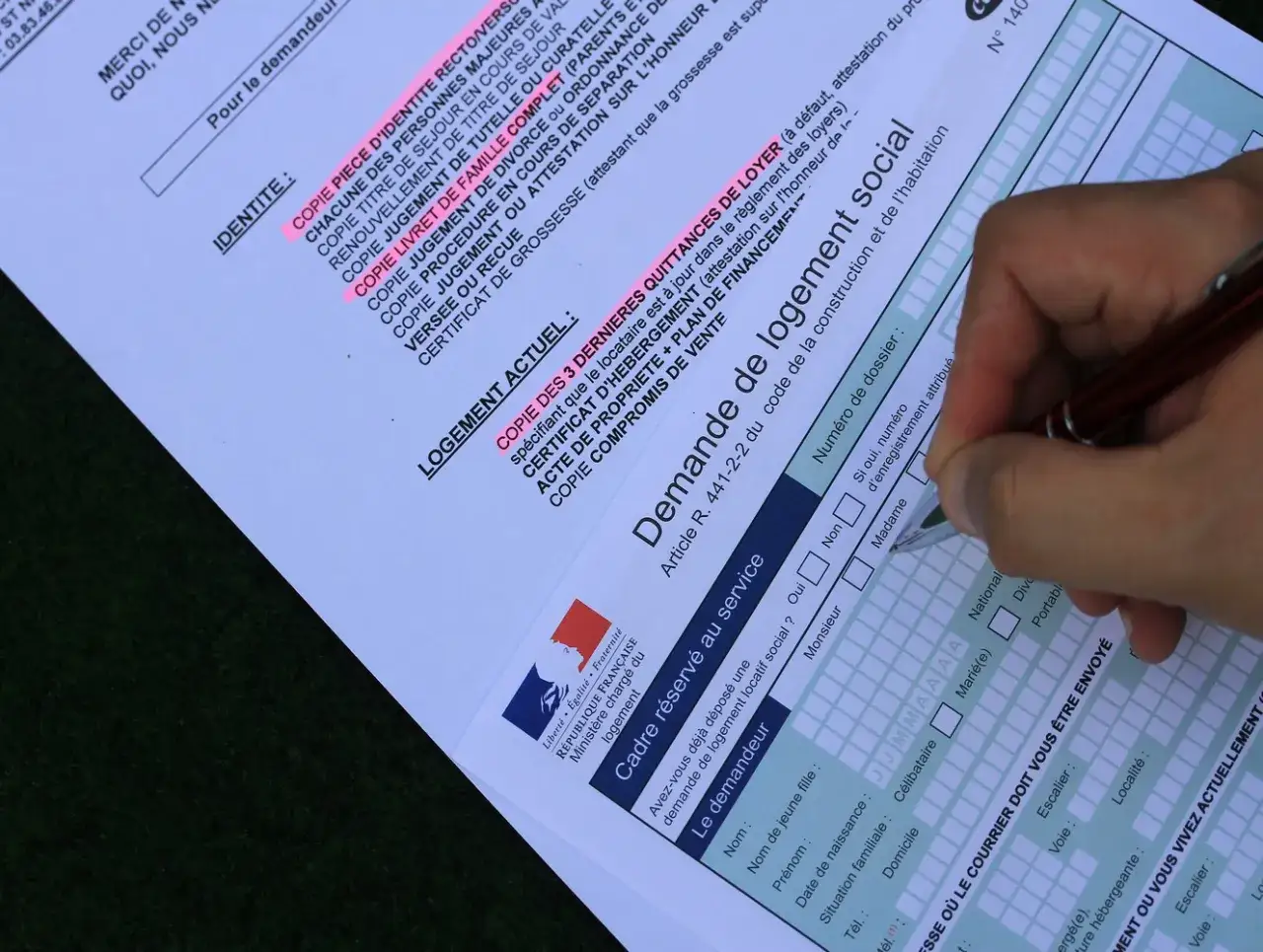 Formulaire de demande de mutation pour un logement social. Un stylo est utilisé pour remplir les champs.