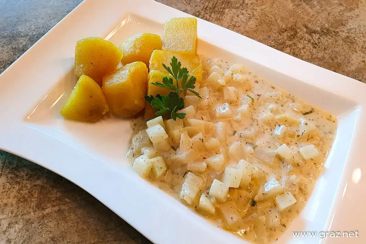 Kohlrabi-Gemüse in cremiger Soße mit Petersilie und Salzkartoffeln. Ein leckeres Gericht, das zeigt, wie vielseitig Kohlrabi ist.