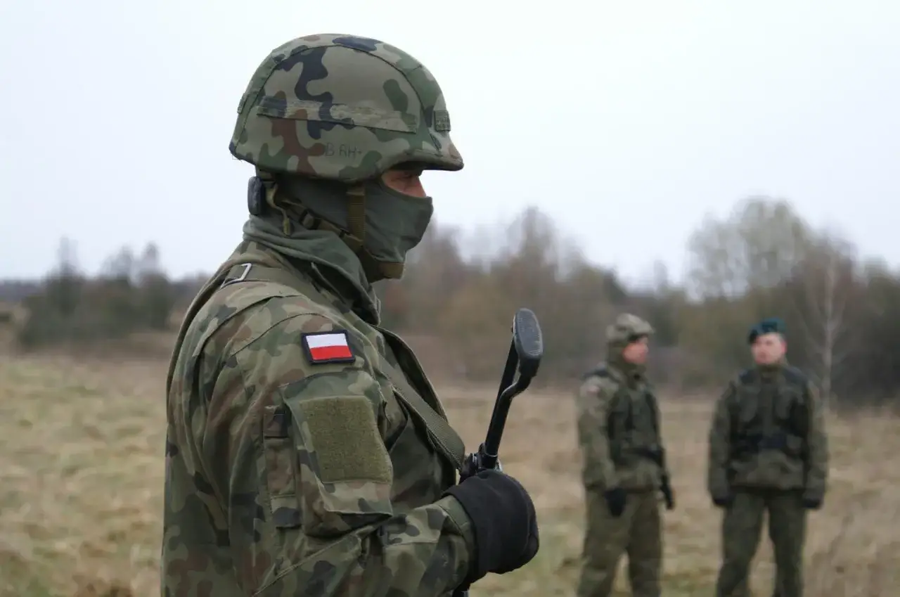 Żołnierz w kamuflażu, z polską flagą na ramieniu, gotowy do służby. Czy to zapowiedź podwyżki w wojsku w 2026 roku?