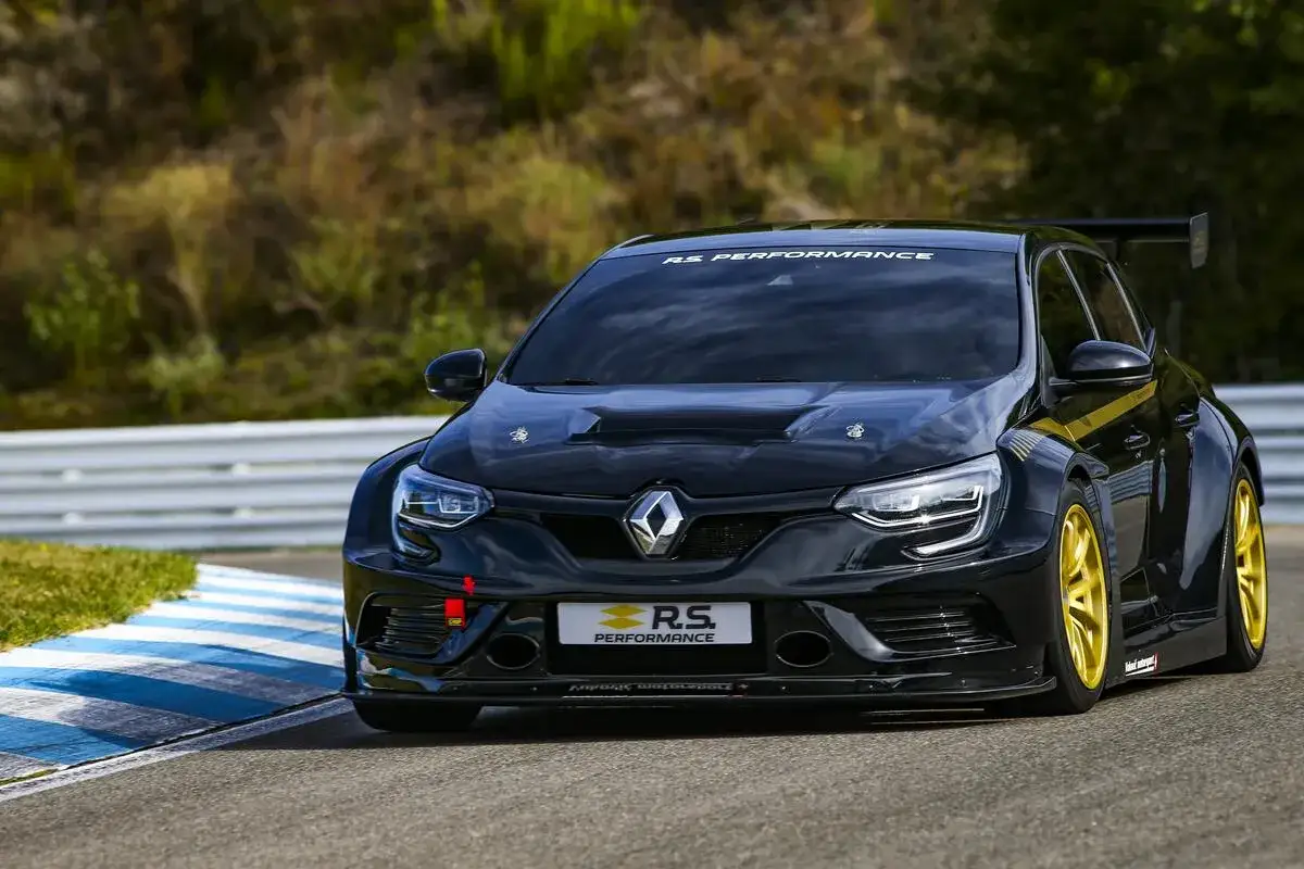 Schwarzer Megane 4 RS auf Rennstrecke, bereit für Höchstleistung. Goldene Felgen und aggressiver Flügel unterstreichen sein sportliches Design.