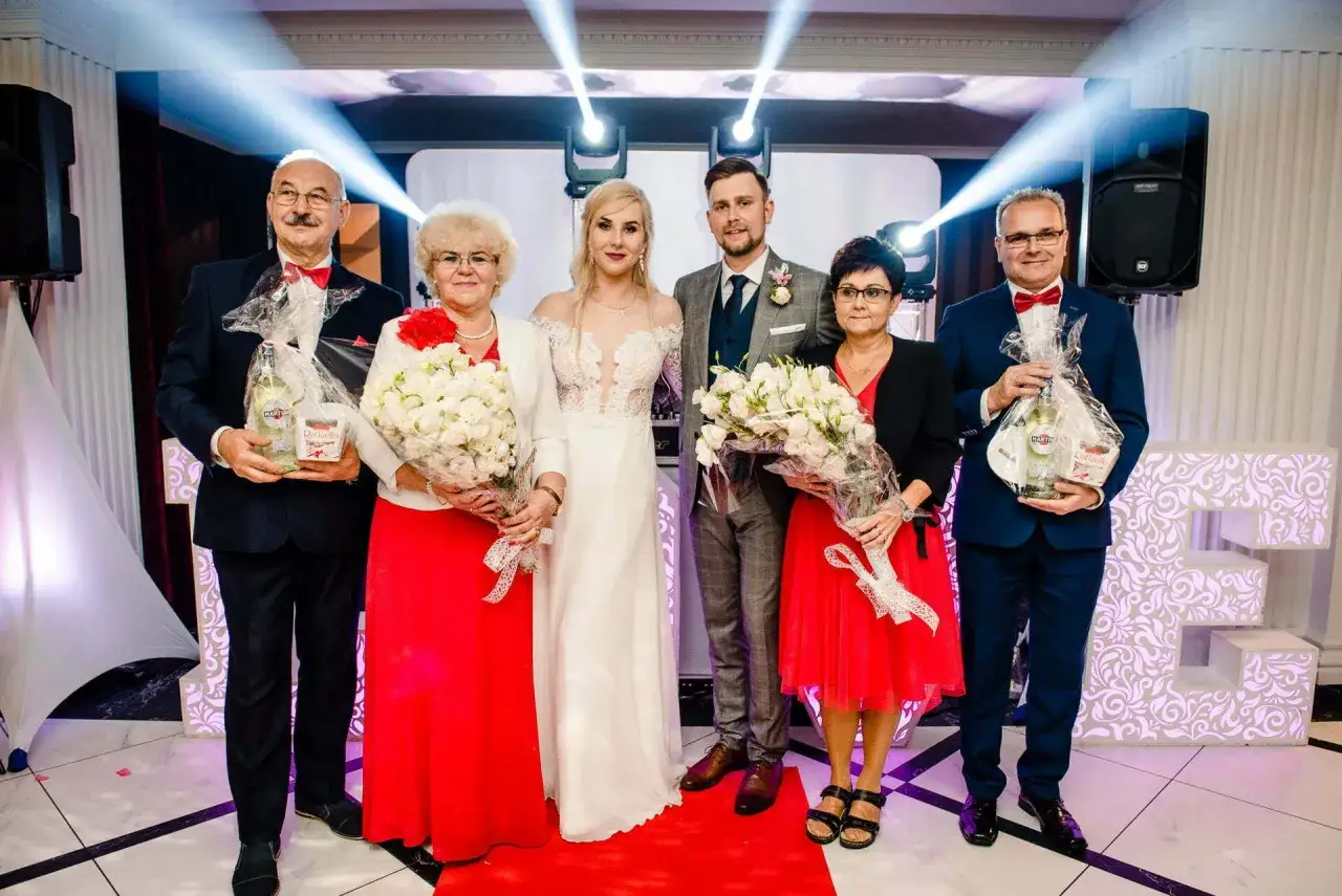 Para rodziców otrzymuje nietypowe podziękowania na weselu: bukiety kwiatów i butelki Martini.