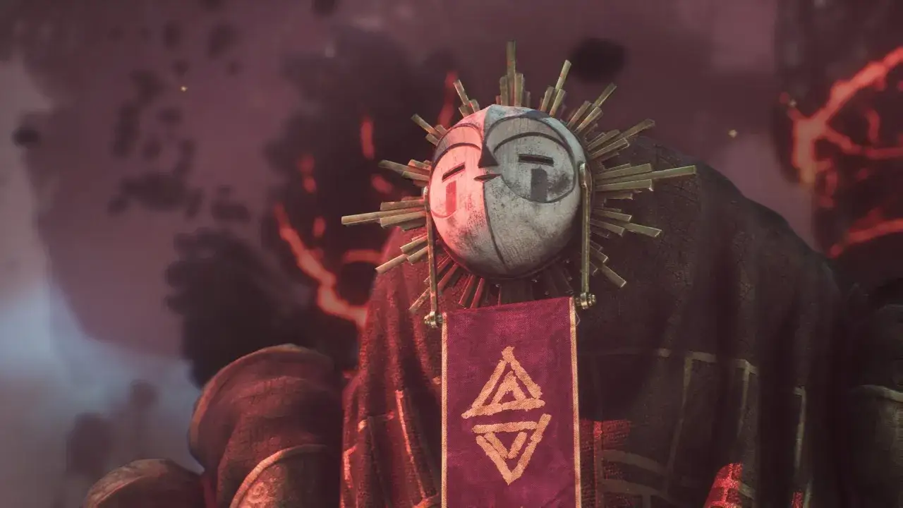 Figura con m&aacute;scara de sol y t&uacute;nica oscura, porta un estandarte con s&iacute;mbolos. Es la gu&iacute;a de la expedici&oacute;n 33.