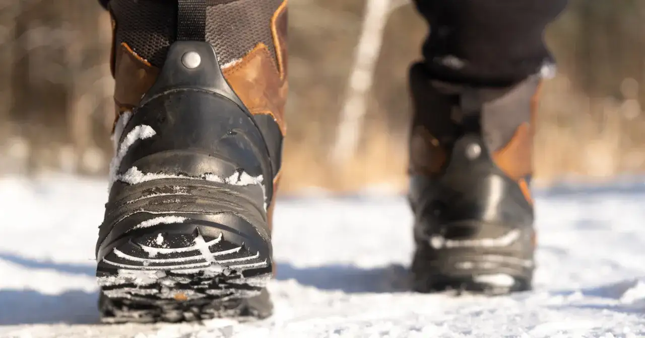 Zimowe buty w śniegu. Chcesz wiedzieć, co zrobić, żeby buty się nie ślizgały? Sprawdź bieżnik i zastosuj antypoślizgowe nakładki.